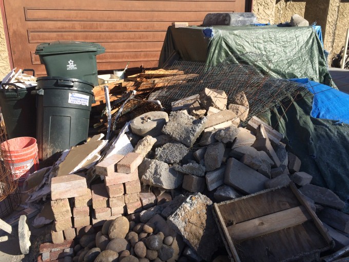 Driveway with all the junk and lay-down for the patio. I removed the patio bricks 18 months before and they've been sitting there until now when I could reinstall them.