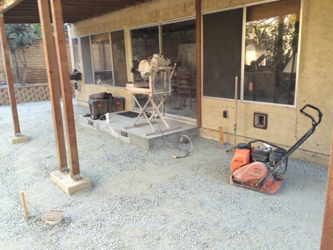 This is the fill all compacted. The orange beast in the foreground is the plate compactor. Also notice the wet say in the background. This tool is essential in making nice cuts for your pavers.